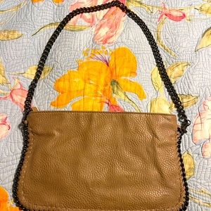 Carlos Santana crossbody with chain strap and surrounding detail.